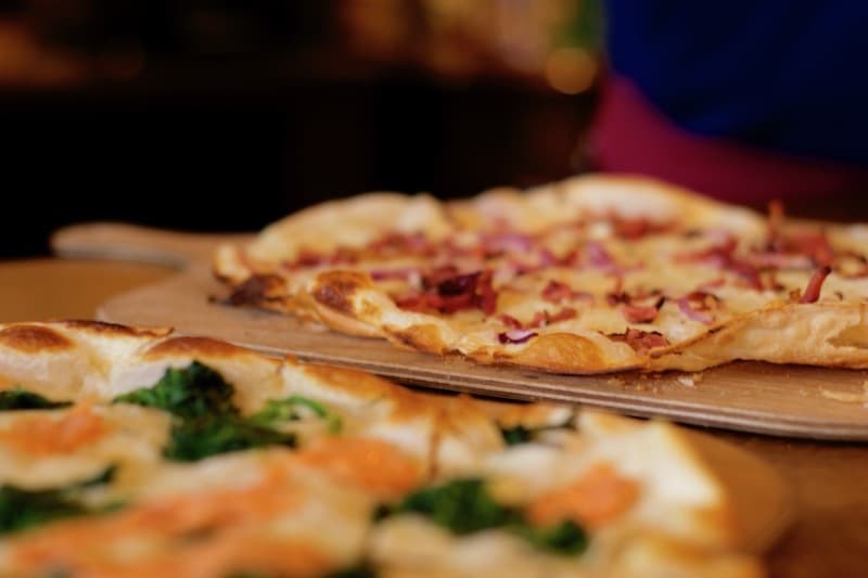 Elsässer Flammkuchen und Flammkuchen Lachs auf Holzbrettern
